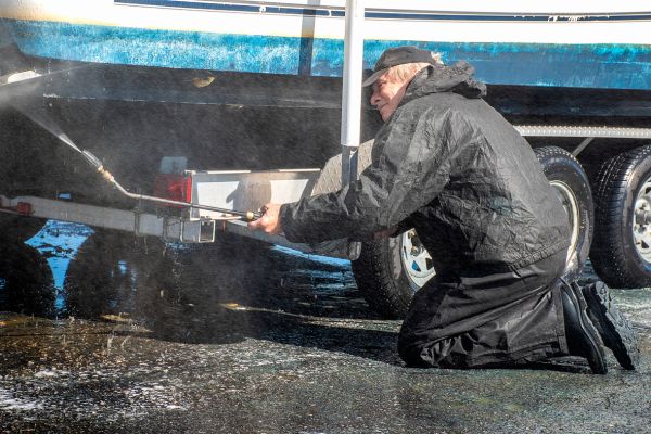 A man cleaning a boat with pressure washer