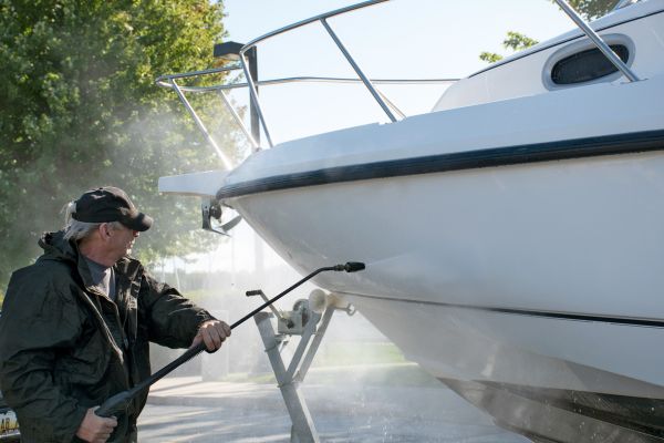 A man pressure cleaning a boat hull