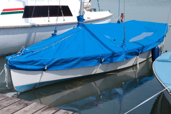 A small fishing boat covered in blue tarp