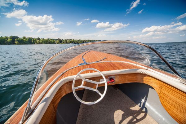 Orange boat with a windshield on a lake